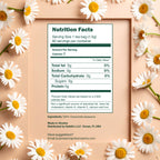 A framed nutrition label for 100% Pure Chamomile Herbal Tea, 60 Bags, is surrounded by soothing chamomile flowers on a peach background, highlighting its caffeine-free benefits.