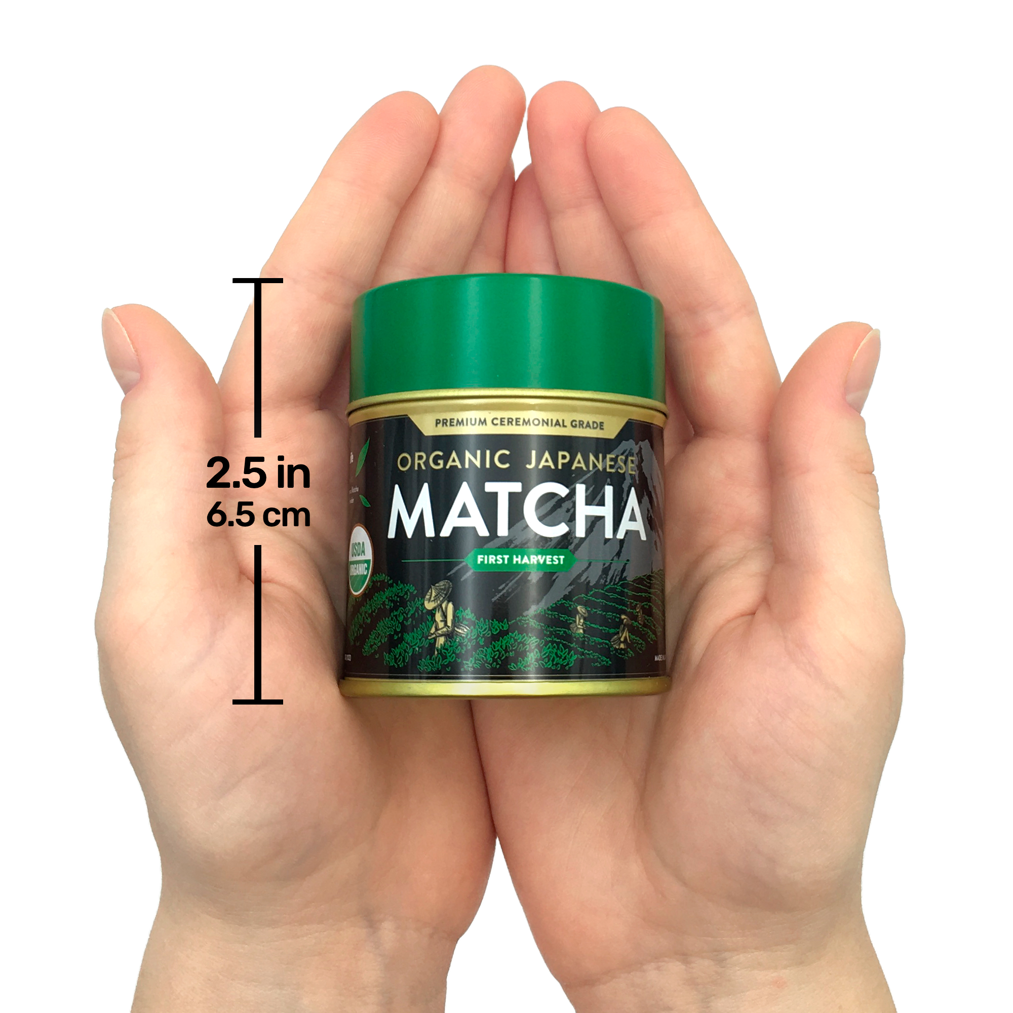 Hands holding a small tin of Organic Japanese Ceremonial Grade Matcha Green Tea Powder with a green lid, labeled "2.5 in, 6.5 cm.