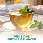 A sunlit glass cup of 100% Pure Peppermint Herbal Tea, caffeine-free with mint leaves on a saucer, and text: "FEEL LIGHT, FRESH & BALANCED." Includes 60 bags for a wellness-focused experience.