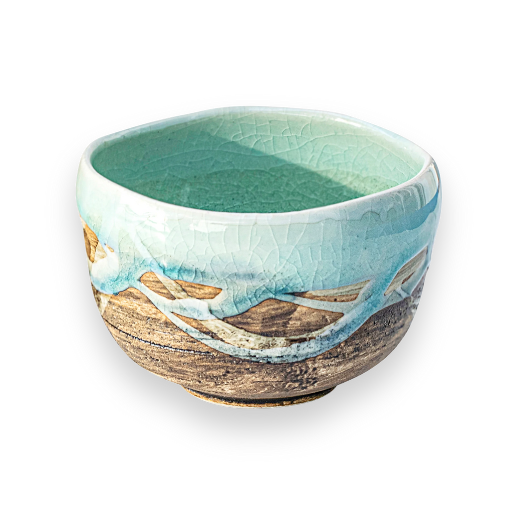 The Japanese Matcha Tea Bowl Blue & Brown Glaze is crafted from Minoyaki pottery, with a turquoise interior and a textured blue and brown exterior—perfect for your Japanese matcha set.