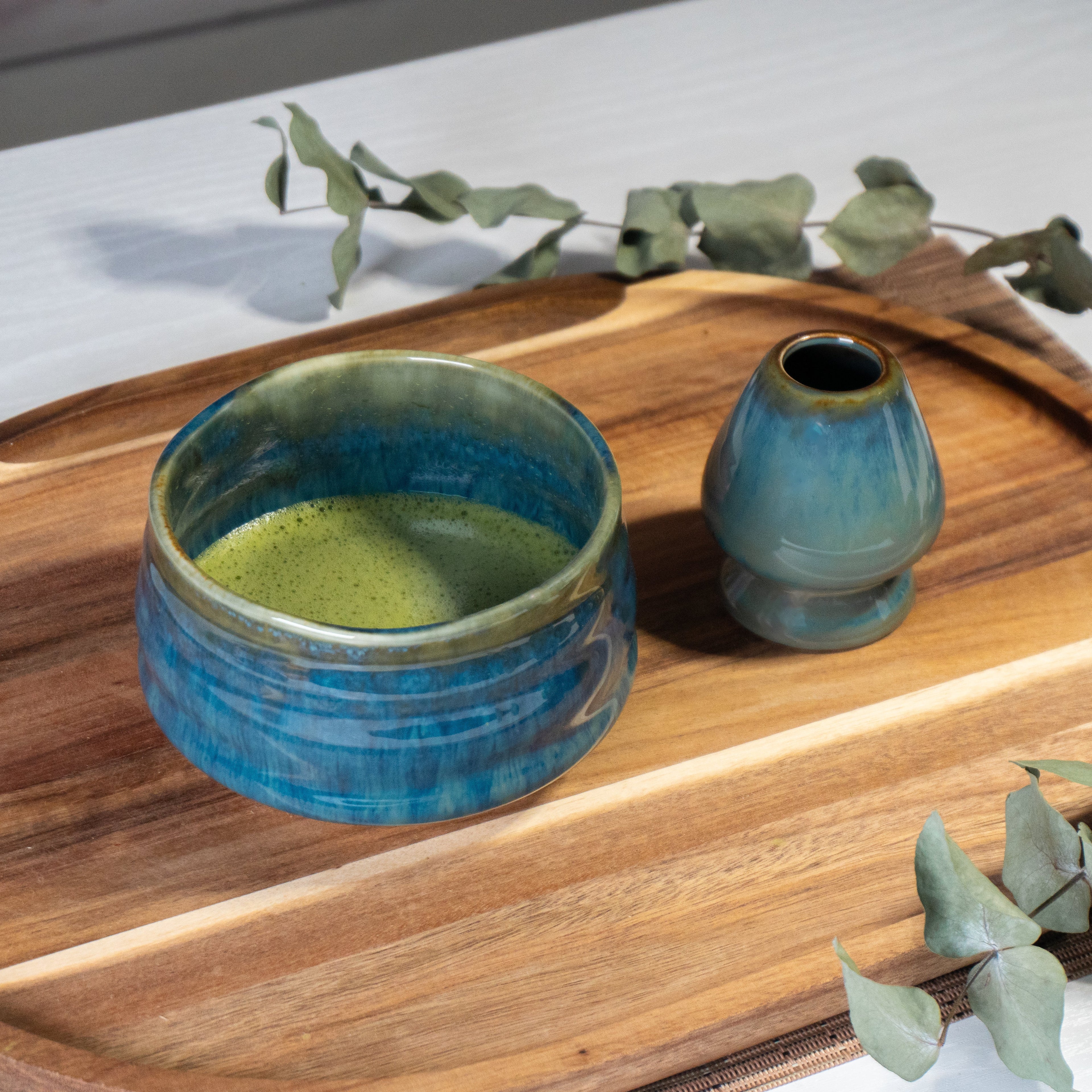 Ceremonial Matcha Starter Kit - Blue: Includes a ceramic bowl with green matcha tea, whisk holder, and wooden tray, inspired by Japanese tea ceremonies—ideal for authentic matcha preparation.