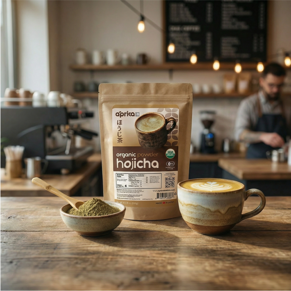 A bag of Hojicha Green Tea Powder, a bowl with powder and spoon, and a latte on a café counter with a barista behind, capturing the rich aroma of Japanese roasted green tea.