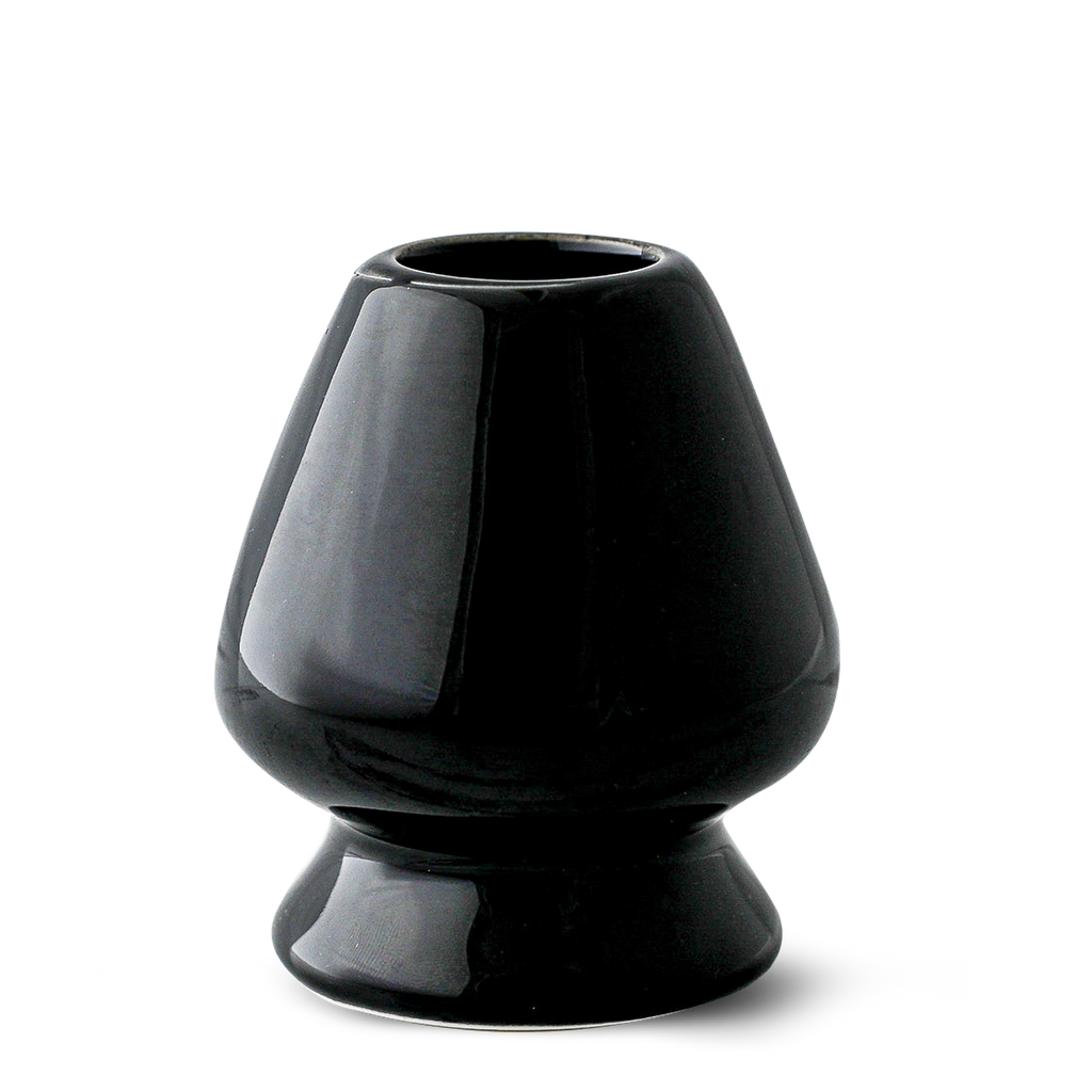 The Black Matcha Whisk Holder from the Black Matcha Whisk Holder and Bamboo Whisk Set exudes a Japanese aesthetic with its glossy ceramic finish, wide base, and narrow top, reminiscent of an elegant matcha whisk holder.