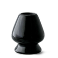 The Black Matcha Whisk Holder from the Black Matcha Whisk Holder and Bamboo Whisk Set exudes a Japanese aesthetic with its glossy ceramic finish, wide base, and narrow top, reminiscent of an elegant matcha whisk holder.
