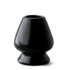 The Black Matcha Whisk Holder from the Black Matcha Whisk Holder and Bamboo Whisk Set exudes a Japanese aesthetic with its glossy ceramic finish, wide base, and narrow top, reminiscent of an elegant matcha whisk holder.