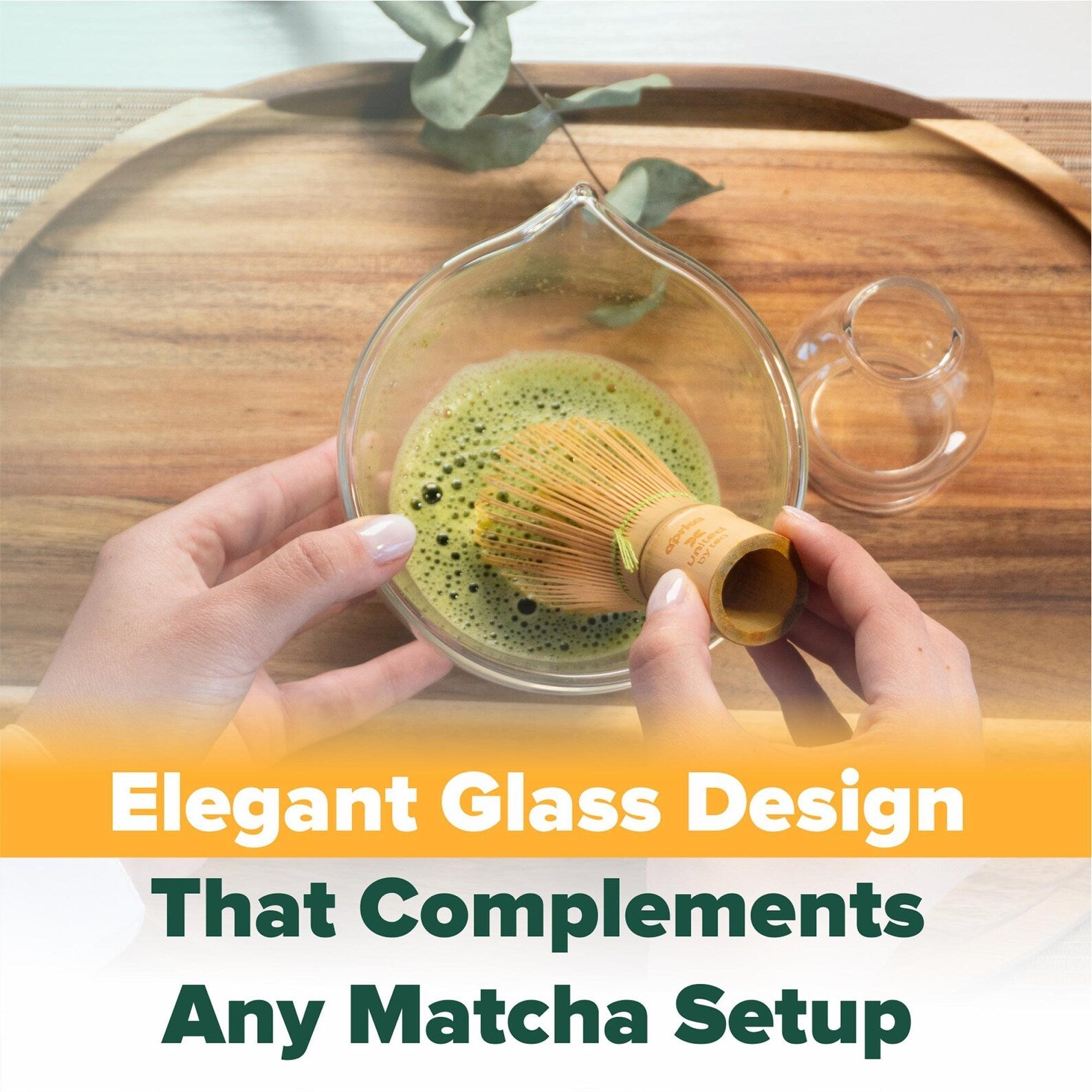 A person whisks matcha in a glass bowl on a wooden tray with the text: "Clear Glass Matcha Whisk Holder and Bamboo Whisk Set—an elegant design that enhances any tea set.