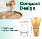 A hand places the bamboo whisk into the Clear Glass Matcha Whisk Holder; a diagram indicates the holder measures 2.5" wide by 3" tall, with design text shown.