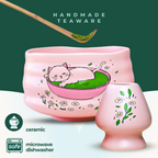 The Pink Unfurl Matcha Gift Set features pink ceramic teaware with hand-painted cat and flower designs. Microwave and dishwasher safe, it makes the perfect gift for matcha lovers.