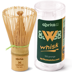 The eco-friendly Bamboo Matcha Whisk (100 Prongs) elegantly rests beside its sleek cylindrical packaging.